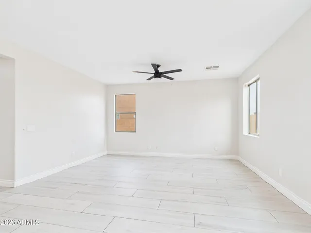 a view of an empty room with window and wooden floor