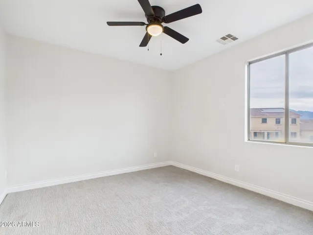 an empty room with chandelier fan