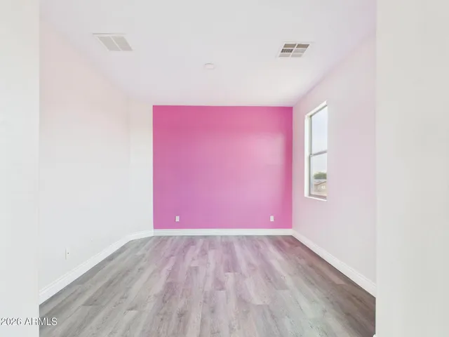 a view of empty room with wooden floor and ceiling fan