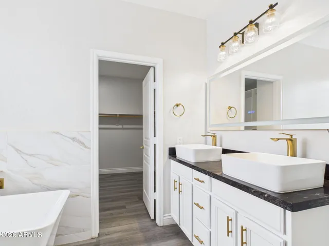 a bathroom with a tub sink and mirror