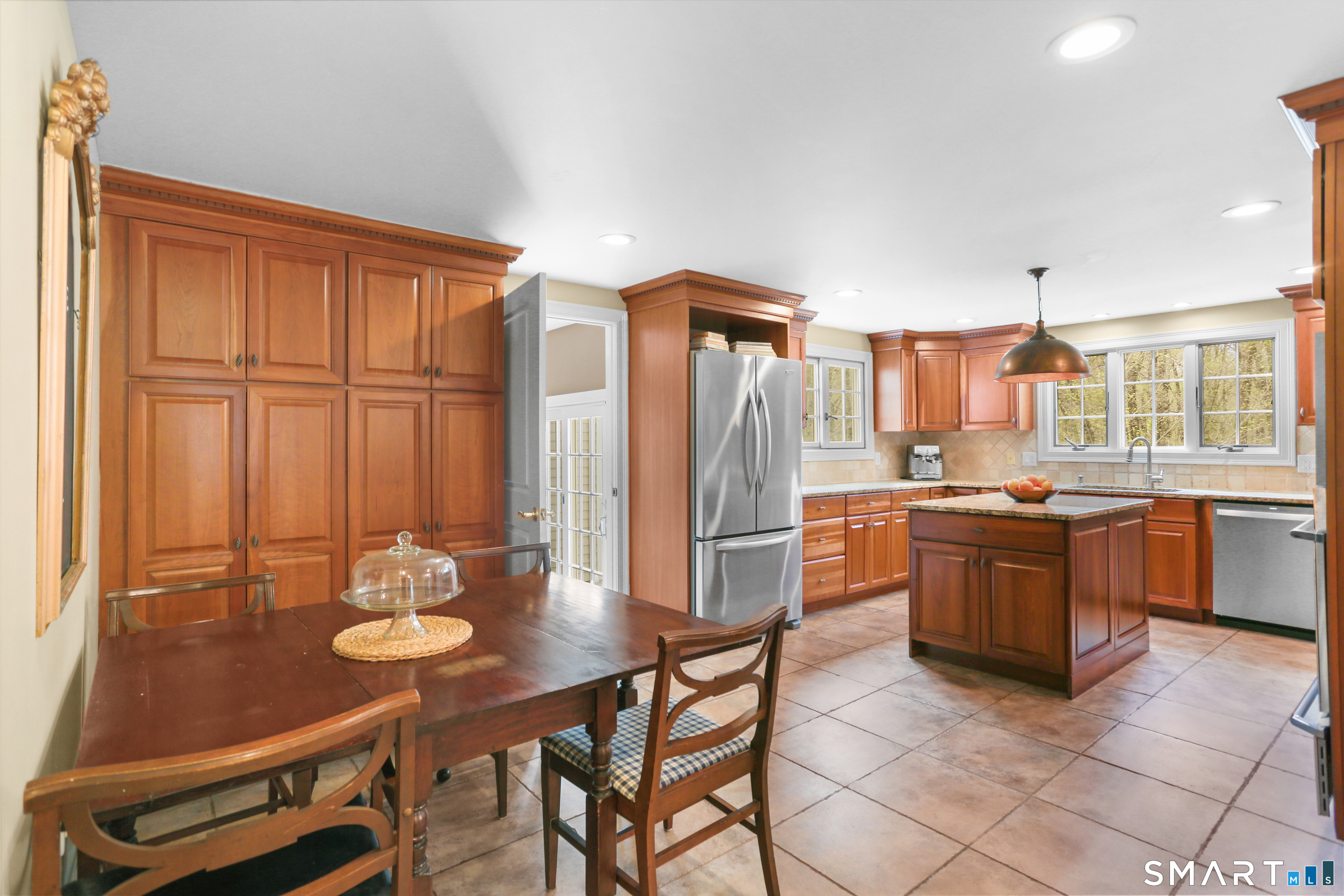4041 Redding Road Fairfield, CT 06824 - Photo 7 of 33 a kitchen with stainless steel appliances granite countertop a stove a refrigerator a sink a dining table and chairs with wooden floor