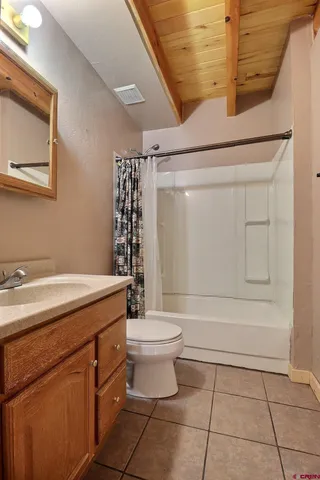 a bathroom with a granite countertop sink a toilet and shower