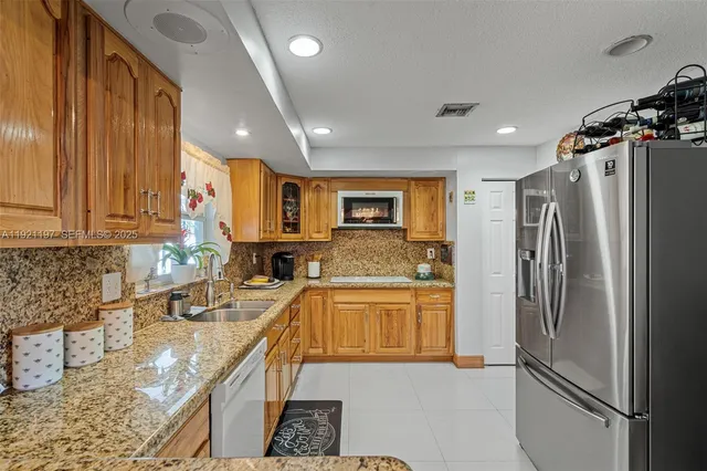 a kitchen with stainless steel appliances granite countertop a sink stove and cabinets