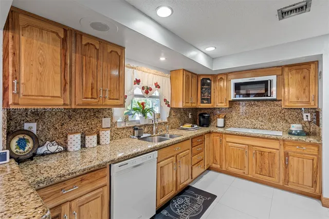 a kitchen with a sink stove top oven and cabinets