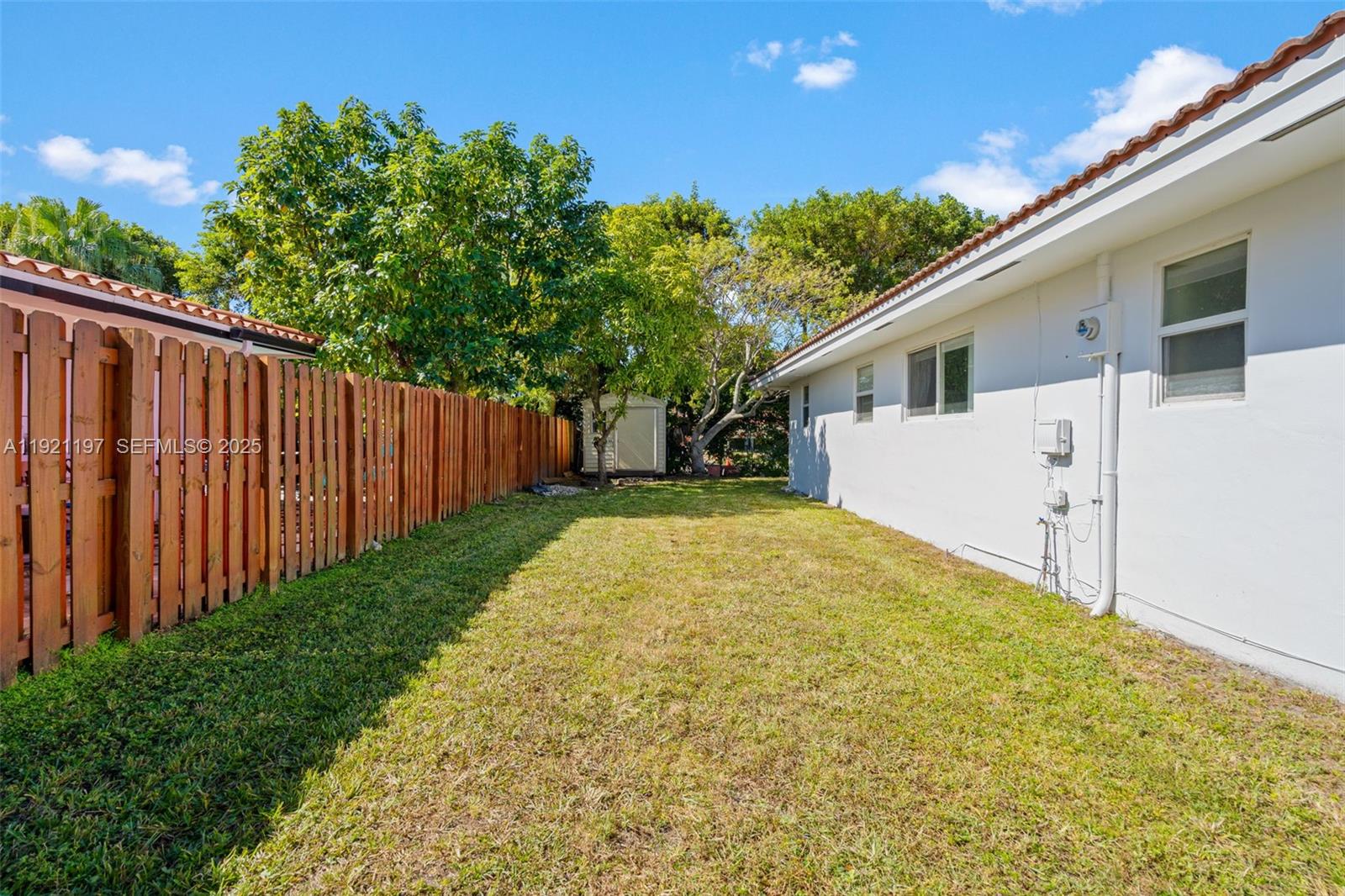 7004 Southwest 139th Place Miami, FL 33183 - Photo 43 of 54 a view of a backyard with large trees and wooden fence