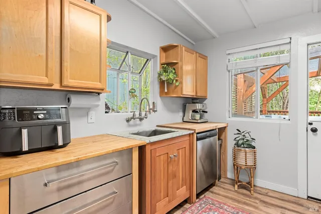 a kitchen with stainless steel appliances granite countertop a sink a stove and a wooden cabinets