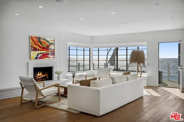 a living room with furniture a fireplace and a floor to ceiling window