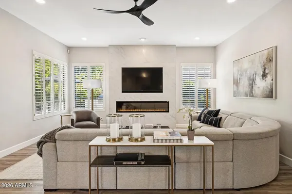 a living room with furniture a flat screen tv and a large window