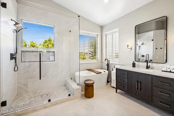 a bathroom with a white bath tub sitting next to a white window