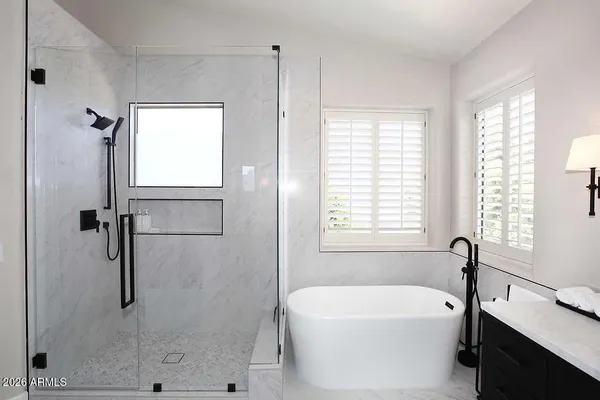 a bathroom with a tub shower and sink