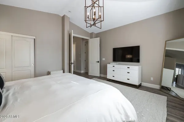 a bedroom with a large bed and a chandelier