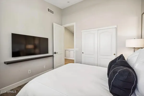 a room with a table chairs wooden floor and a window