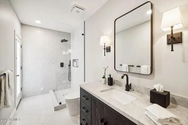a bathroom with a granite countertop sink toilet and shower