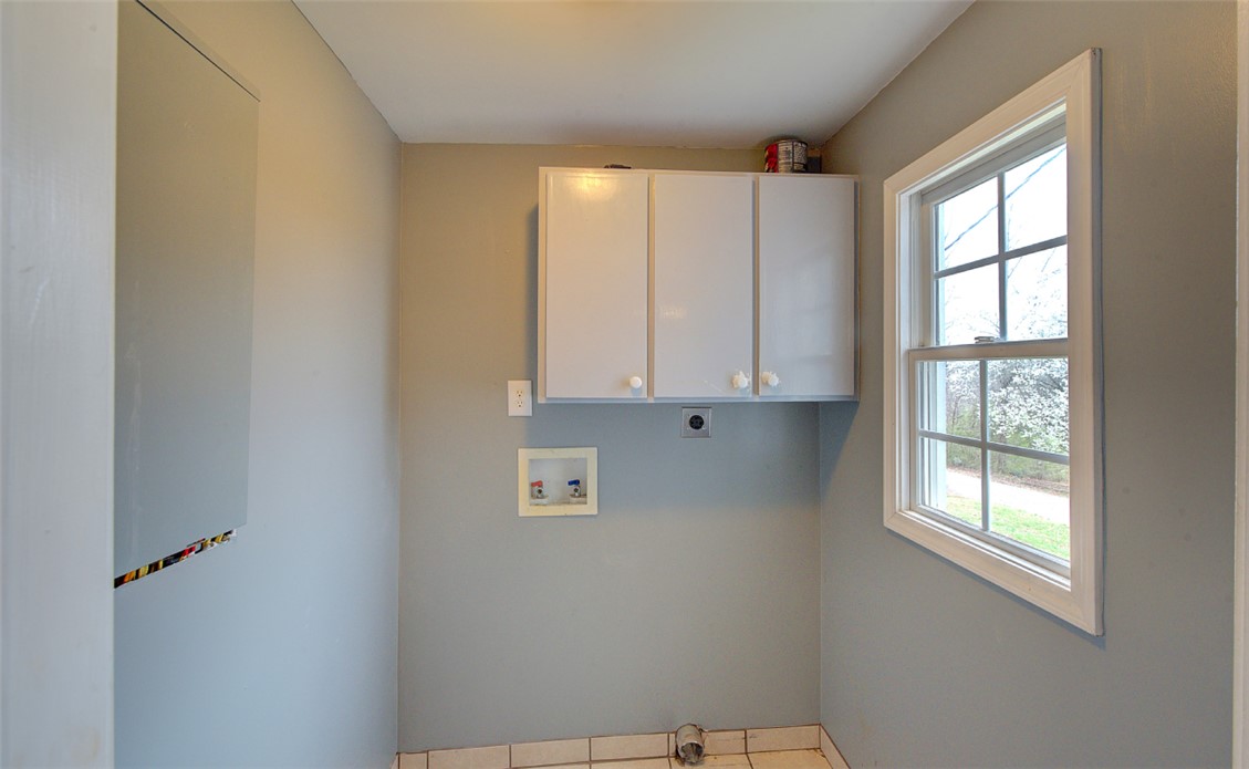 325 Rock Quarry Road Travelers Rest, SC 29690 - Photo 28 of 37 This functional laundry area features ample storage, a window, and durable tile flooring for everyday convenience.