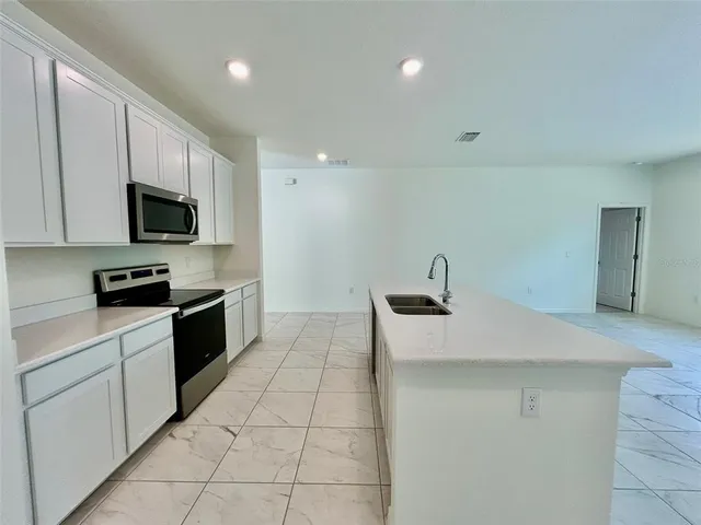 a kitchen with stainless steel appliances a sink dishwasher stove top oven and cabinets