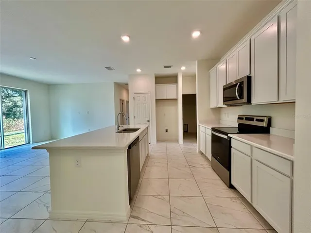 a kitchen with stainless steel appliances granite countertop a stove a sink and a refrigerator