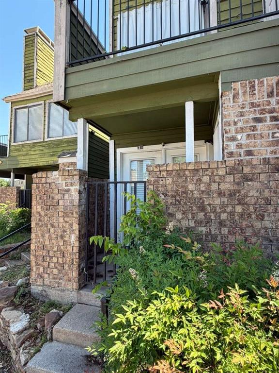 9815 Walnut Street, Unit 102 Dallas, TX 75243 - Photo 3 of 13 Brick exterior facade featuring a covered entry