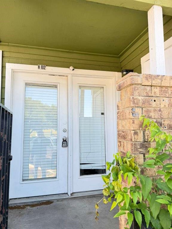9815 Walnut Street, Unit 102 Dallas, TX 75243 - Photo 4 of 13 Double white glass-panel doors beneath a green soffit