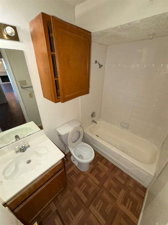 9815 Walnut Street, Unit 102 Dallas, TX 75243 - Photo 7 of 13 Bathroom featuring a white vanity with integrated sink, wood-finish base cabinetry, and a mirrored backsplash