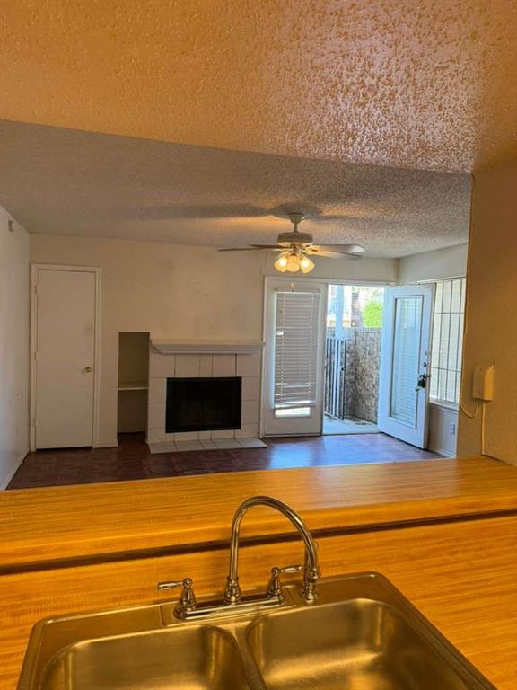 9815 Walnut Street, Unit 102 Dallas, TX 75243 - Photo 10 of 13 Kitchen pass-through featuring wood-finish countertops and a double stainless steel sink with a chrome faucet