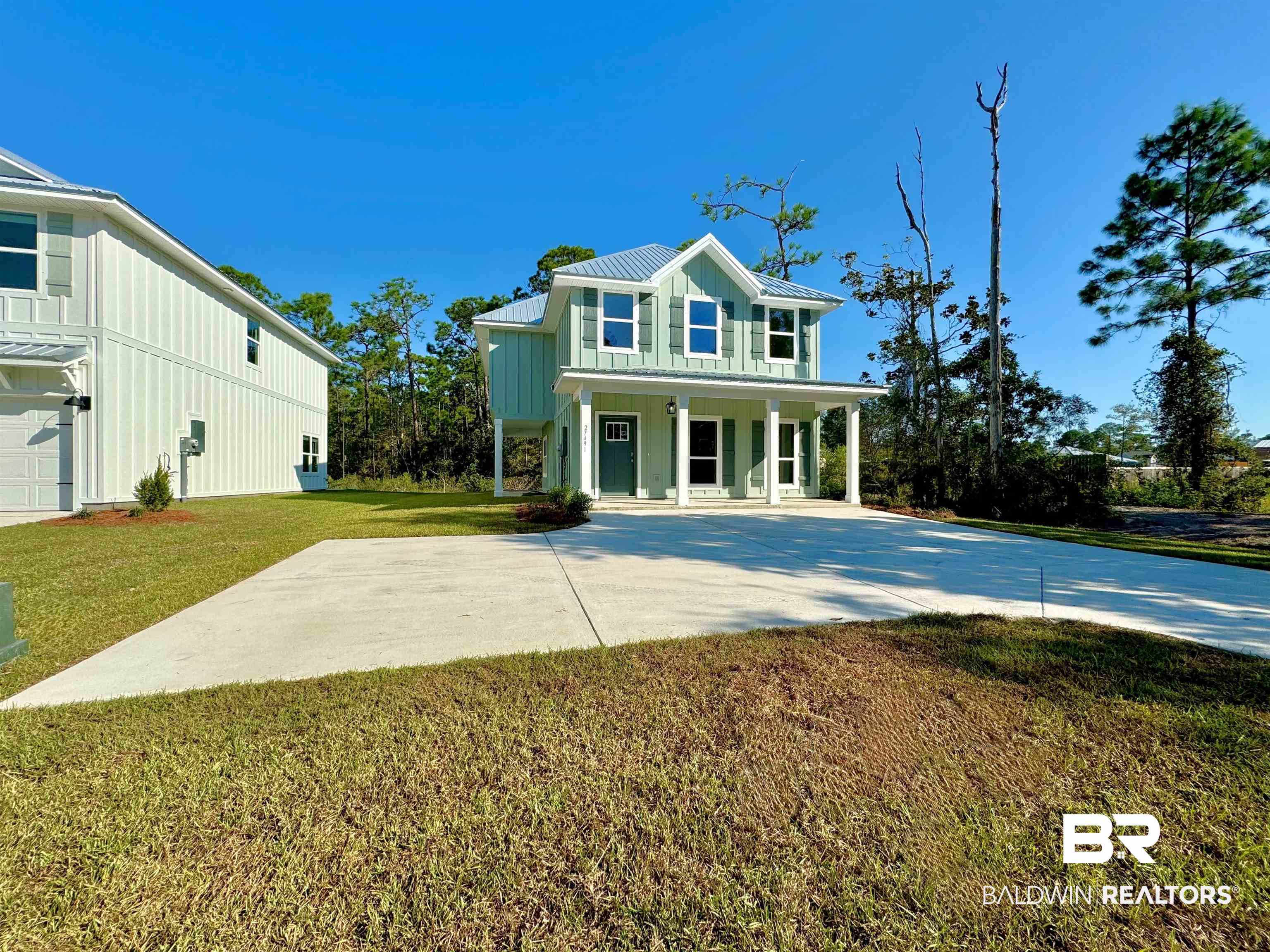 27491 Canal Road Orange Beach, AL 36561 - Photo 2 of 20 View of front of home with a garage, a porch, and a front lawn