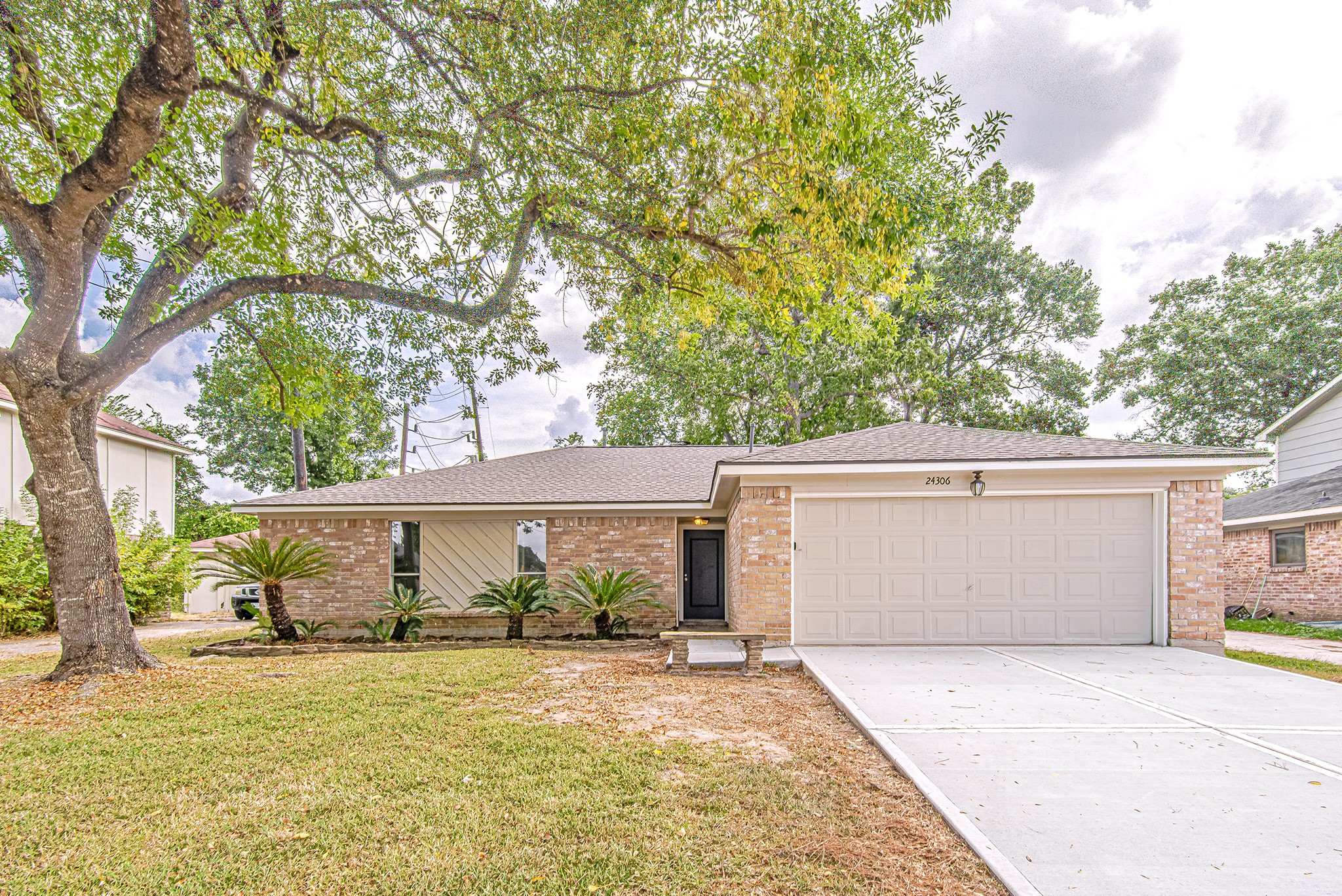24306 Spring Mill Lane Spring, TX 77373 - Photo 2 of 24 a view of a white house with a large tree and plants