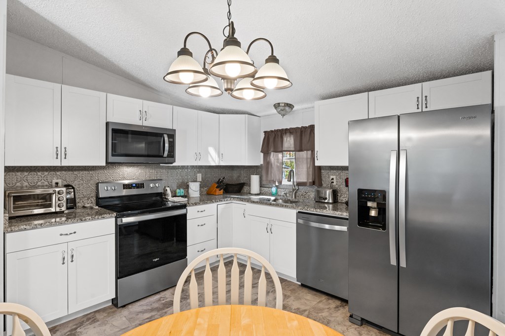 39 Red Bush School Road Blue Ridge, GA 30513 - Photo 20 of 36 a kitchen with stainless steel appliances granite countertop a refrigerator a stove top oven a sink and dishwasher