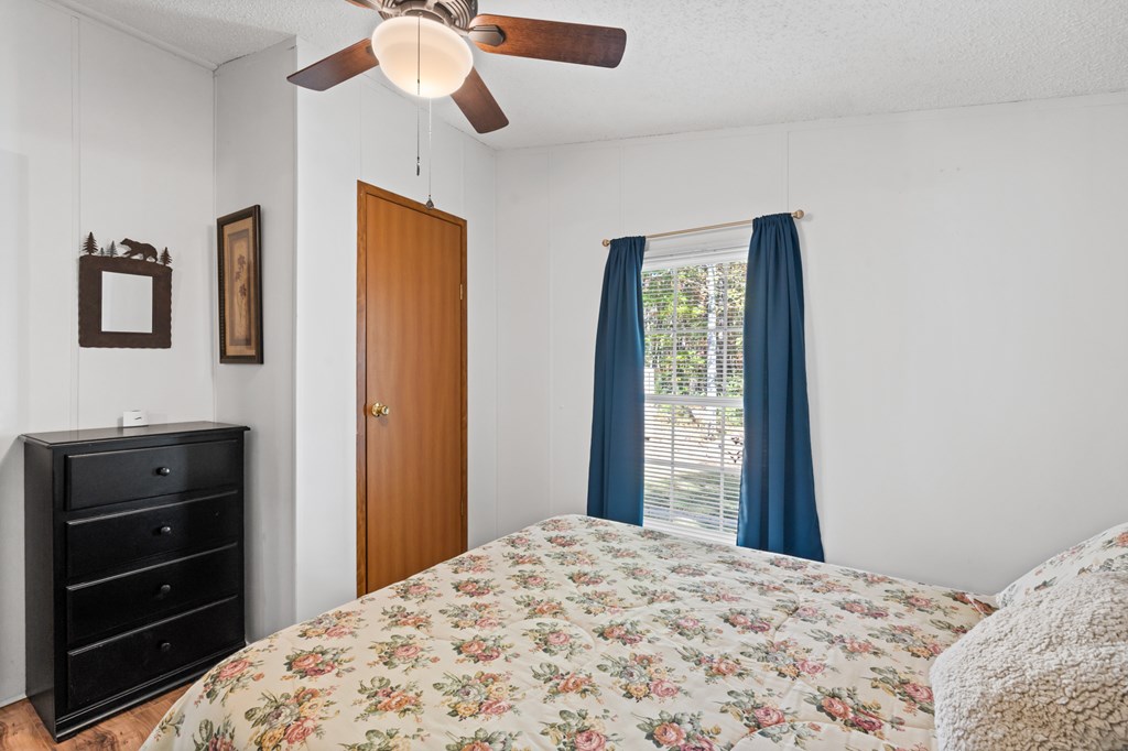 39 Red Bush School Road Blue Ridge, GA 30513 - Photo 24 of 36 a bedroom with a bed and a chandelier