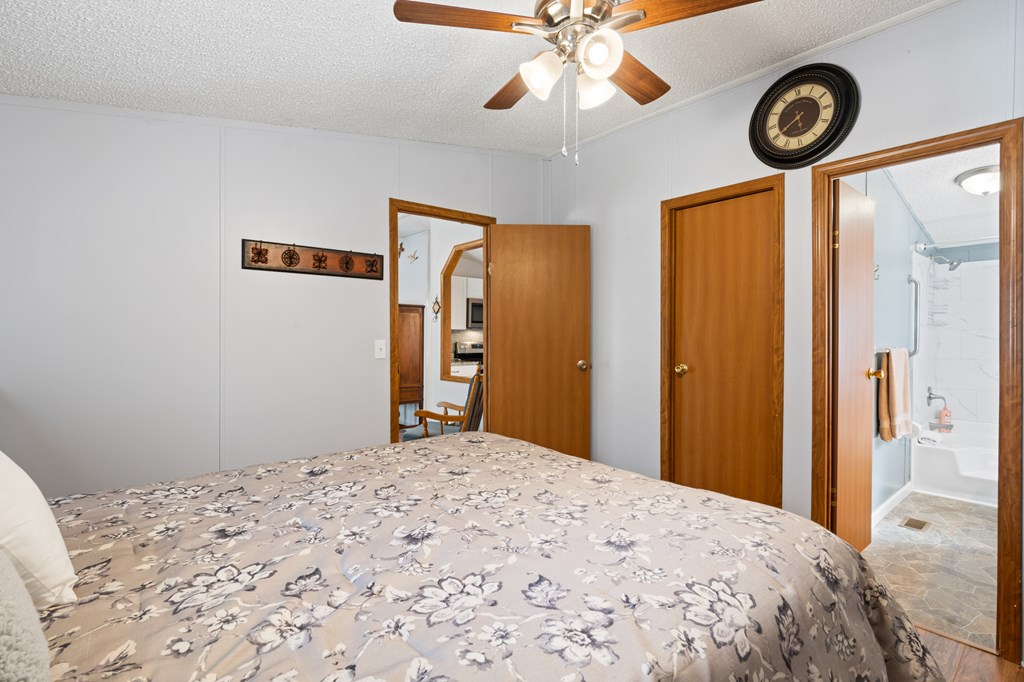 39 Red Bush School Road Blue Ridge, GA 30513 - Photo 30 of 36 a bedroom with a large bed and a chandelier