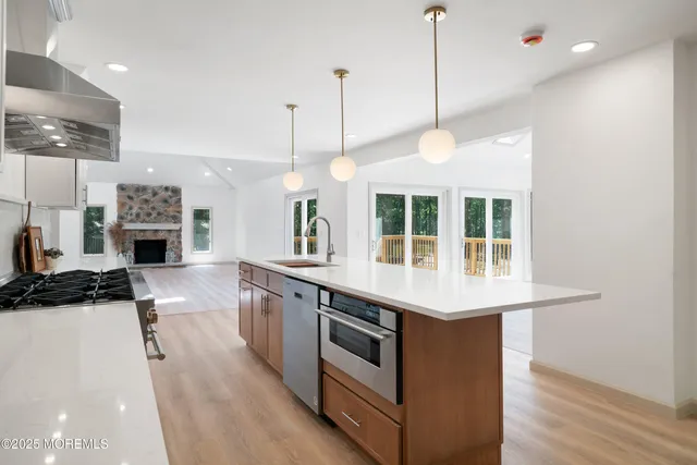 an empty room with wooden floor fireplace and windows