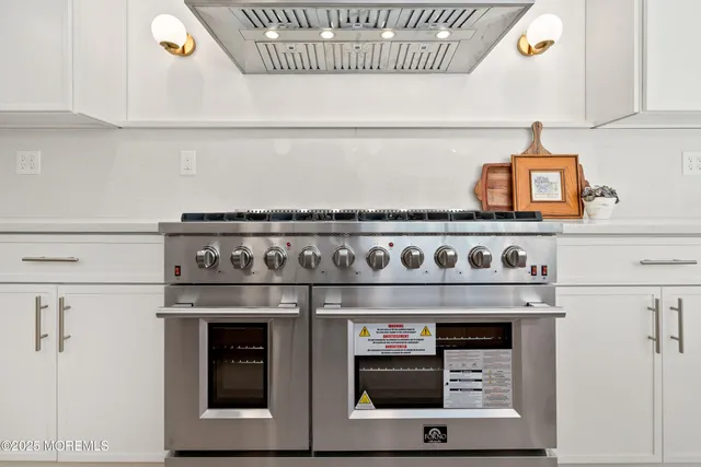 a view of an empty room with a kitchen and a window