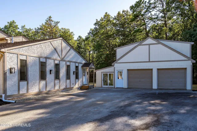 a large kitchen with a large counter top a sink stainless steel appliances and cabinets