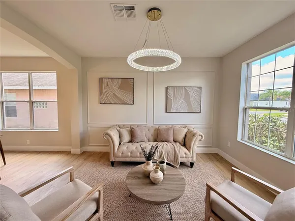 a living room with furniture and a dining table with wooden floor