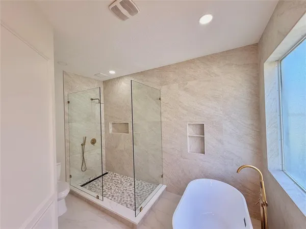 a bathroom with a sink a toilet and shower