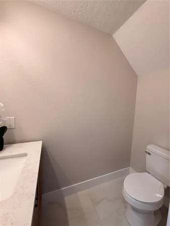 a bathroom with a sink mirror and toilet