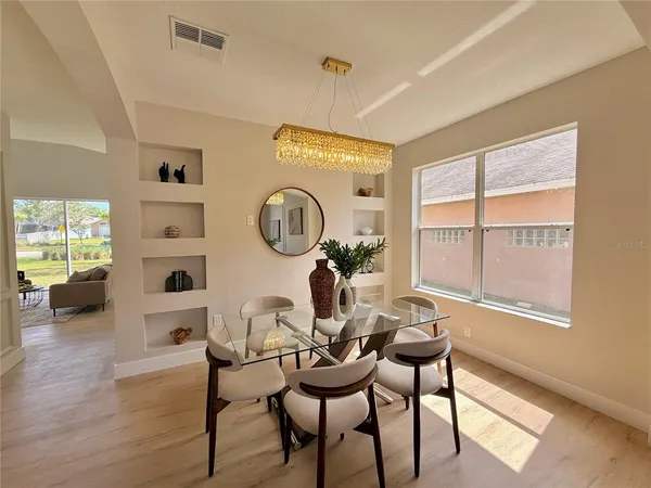 a kitchen with stainless steel appliances kitchen island granite countertop a sink a stove a dining table and chairs