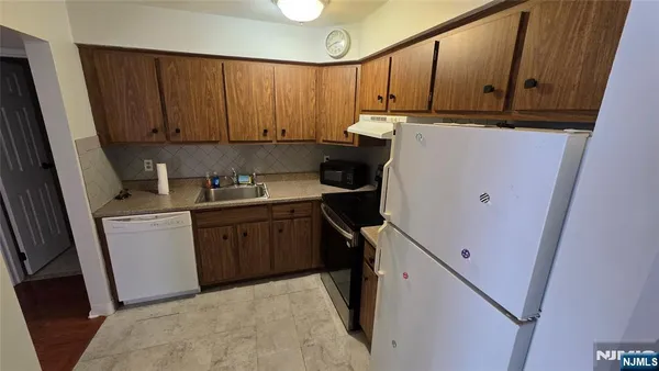 a kitchen with a refrigerator sink and cabinets