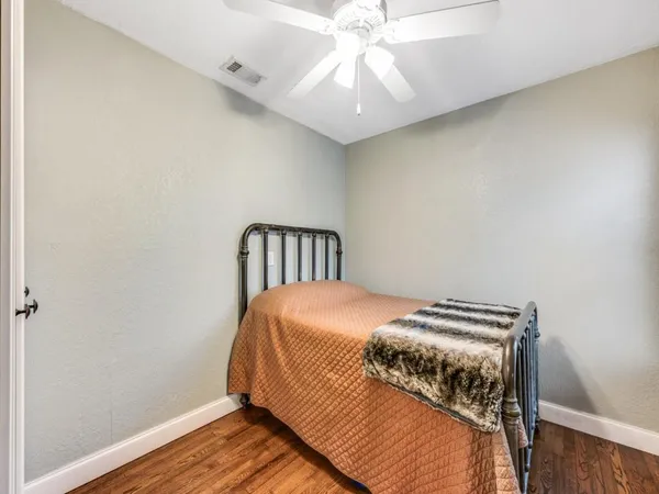 a bedroom with bed and wooden floor