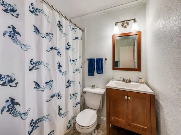 a bathroom with a toilet sink and mirror