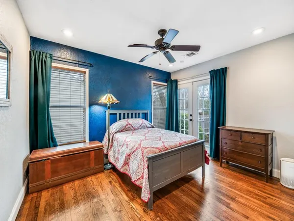 a bed sitting in a spacious bedroom next to a window