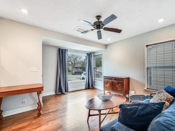 a living room with furniture and a wooden floor