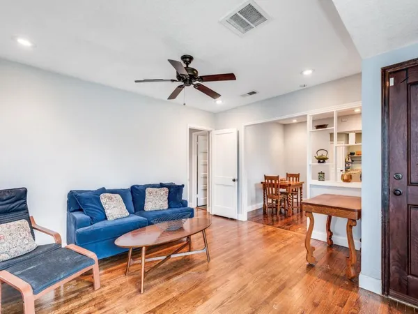 a living room with furniture and a wooden floor