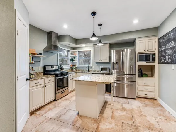 a kitchen with stainless steel appliances kitchen island granite countertop a sink and cabinets