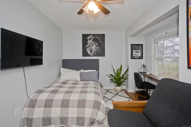 a bedroom with a bed a couch and a flat screen tv