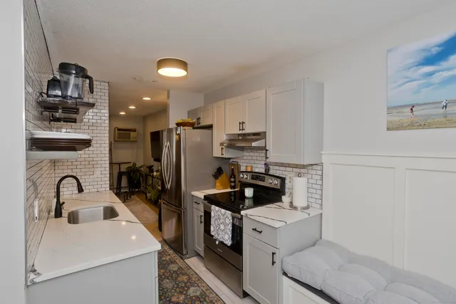 a kitchen that has a sink cabinets and stainless steel appliances