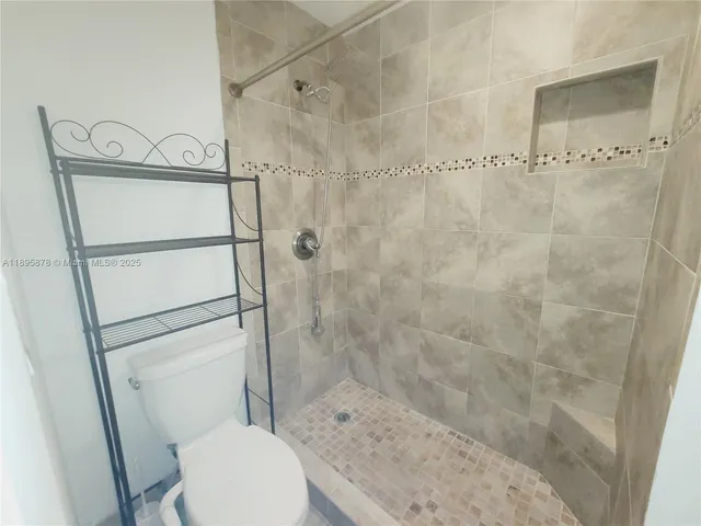 a bathroom with a toilet and a shower