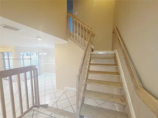 a view of staircase with lots of frames on wall and wooden floor