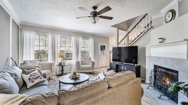 a living room with furniture a fireplace and a flat screen tv