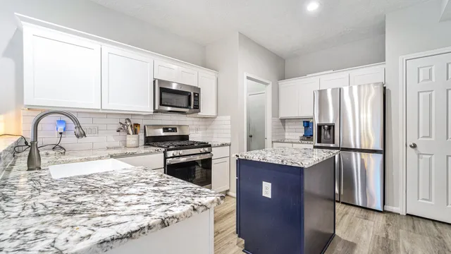 a kitchen with a refrigerator stove top oven and sink