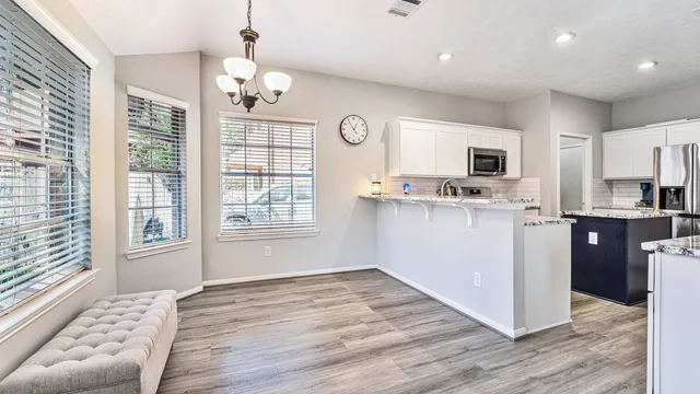 a kitchen with kitchen island granite countertop a stove top oven a sink a counter space and cabinets